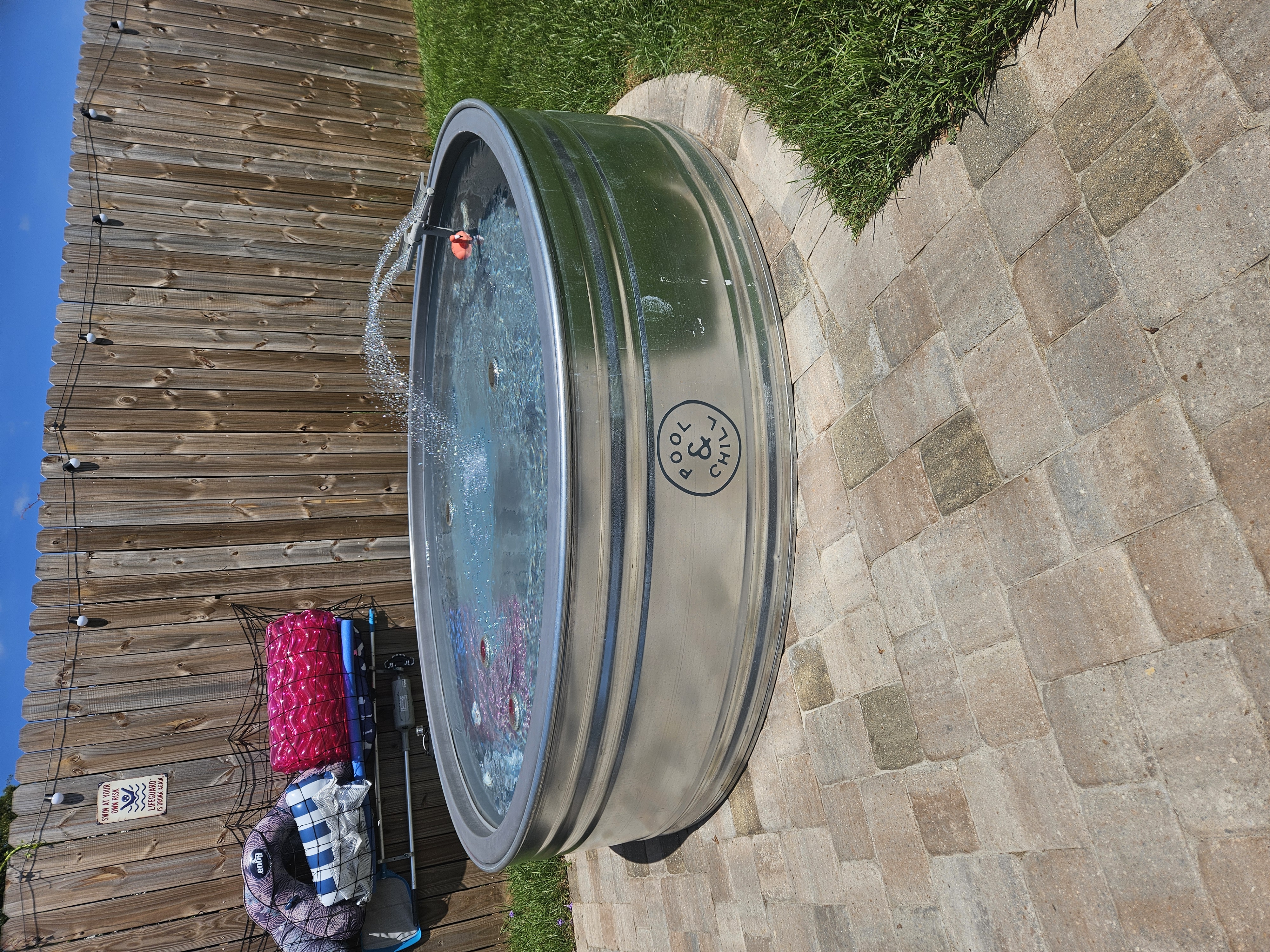 Finished 8-foot galvanized stock tank pool installed on a backyard paver patio in Florida