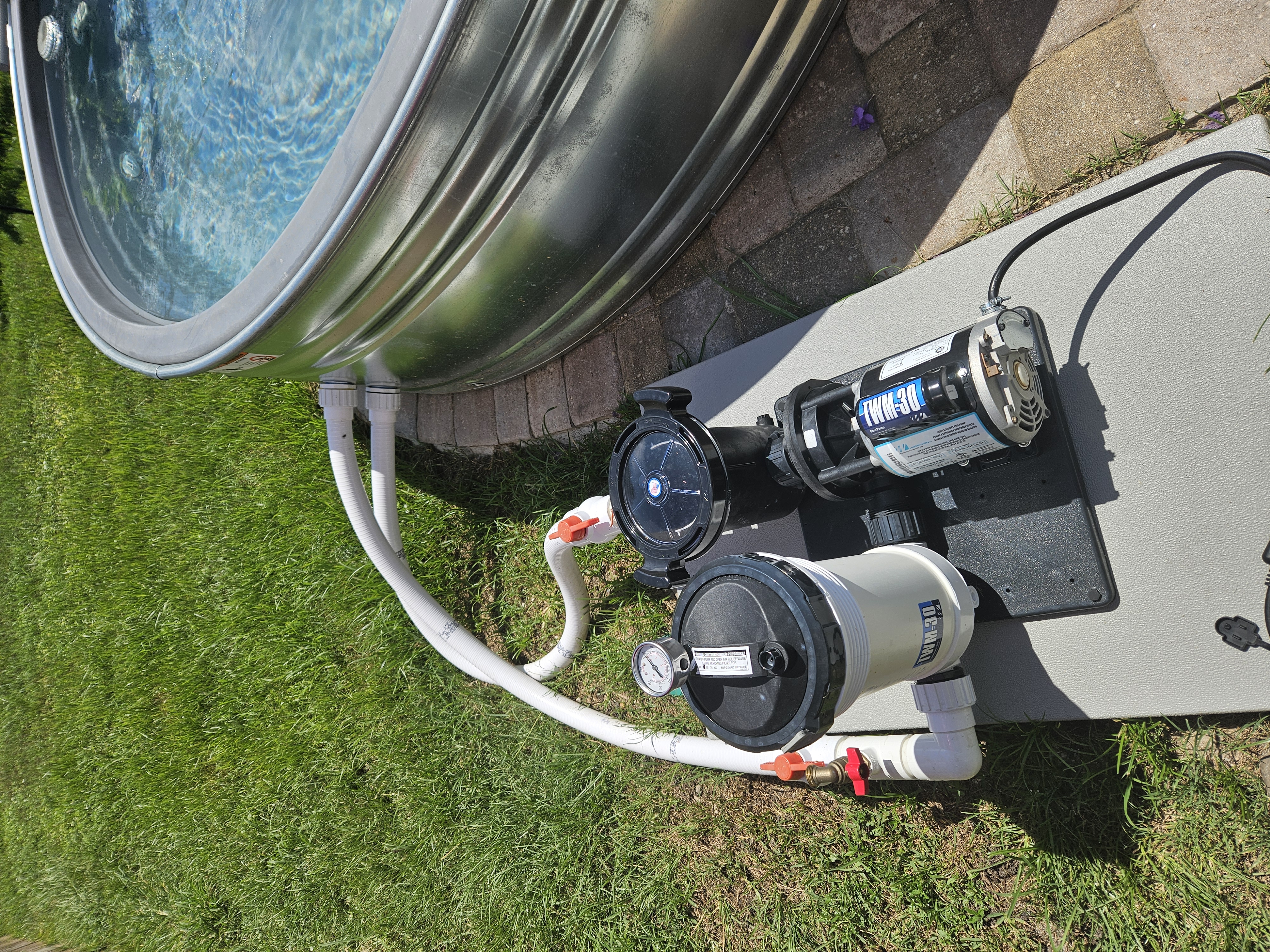 Pump filter hoses valves and plumbing connected to an 8-foot stock tank pool